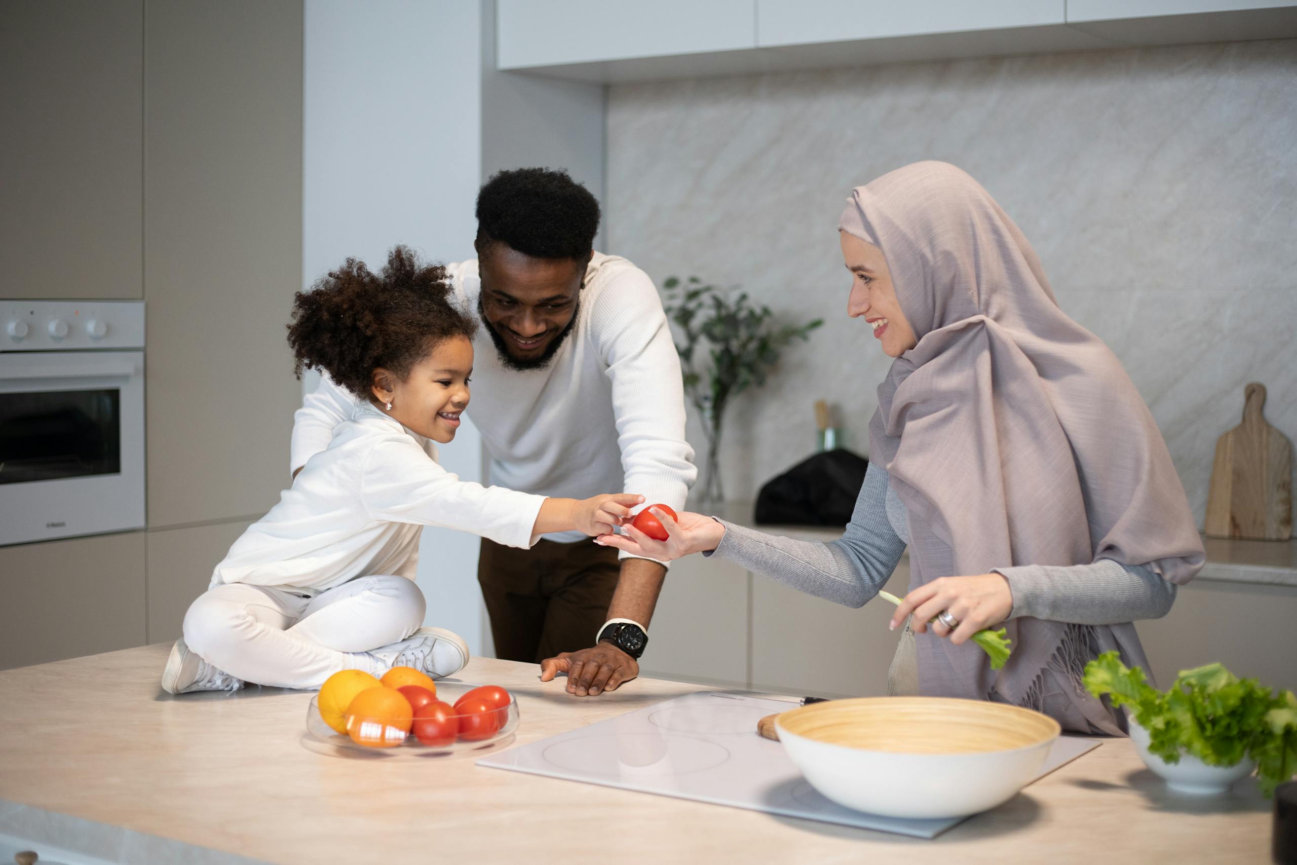 A joyful family scene with a mother, father, and child preparing a meal in a modern kitchen.